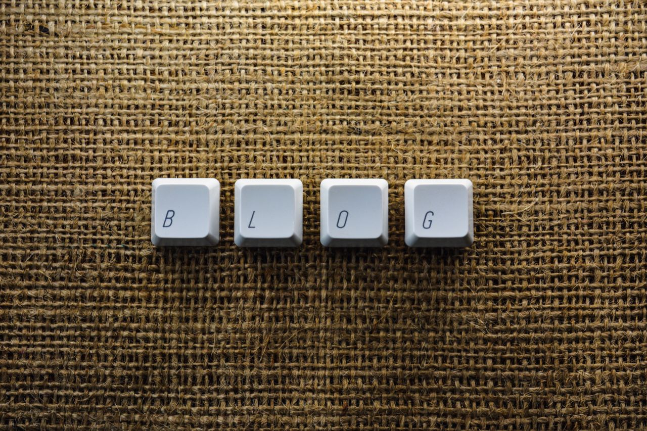Close-up of keyboard keys spelling BLOG on a burlap surface, ideal for tech blogs.